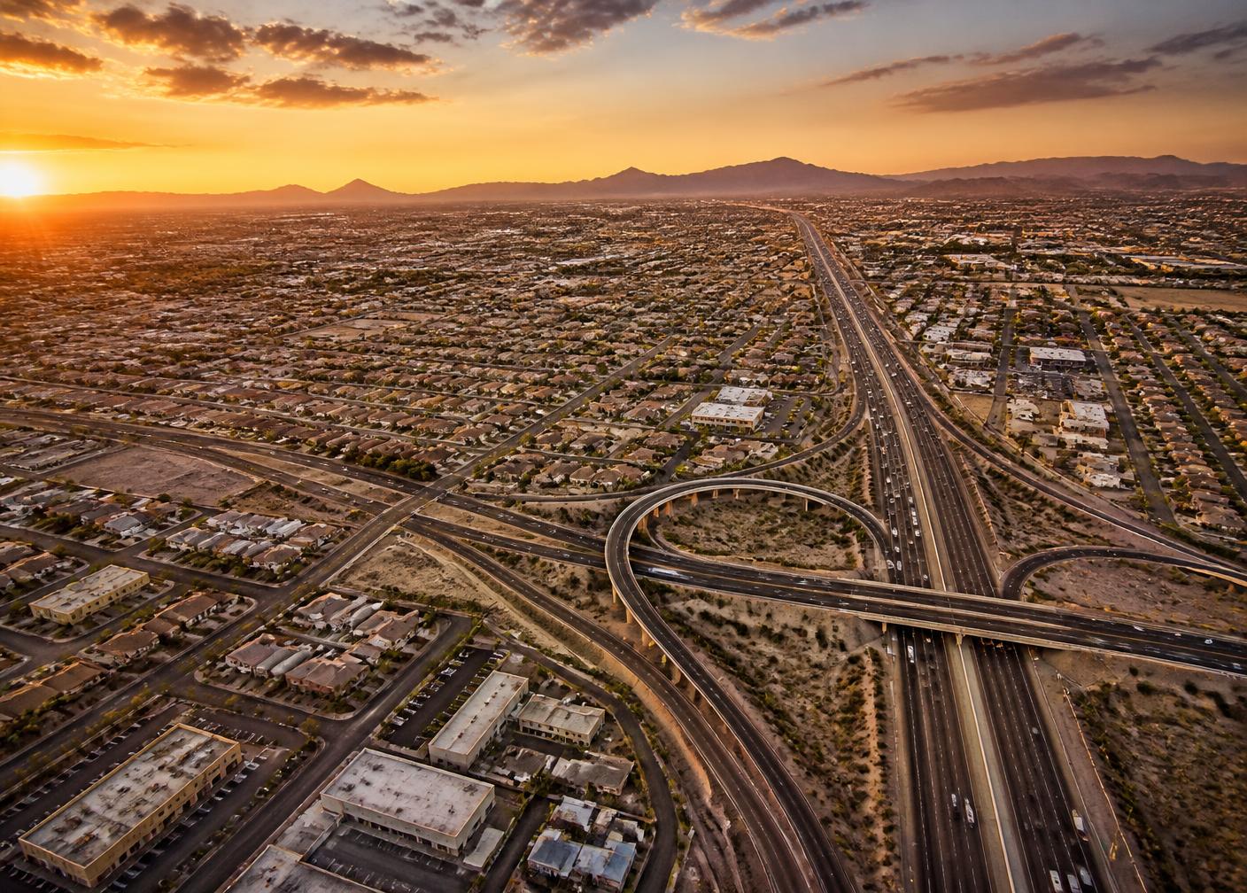 Aerial view of North Phoenix at sunset with the freeway interchange and desert mountains